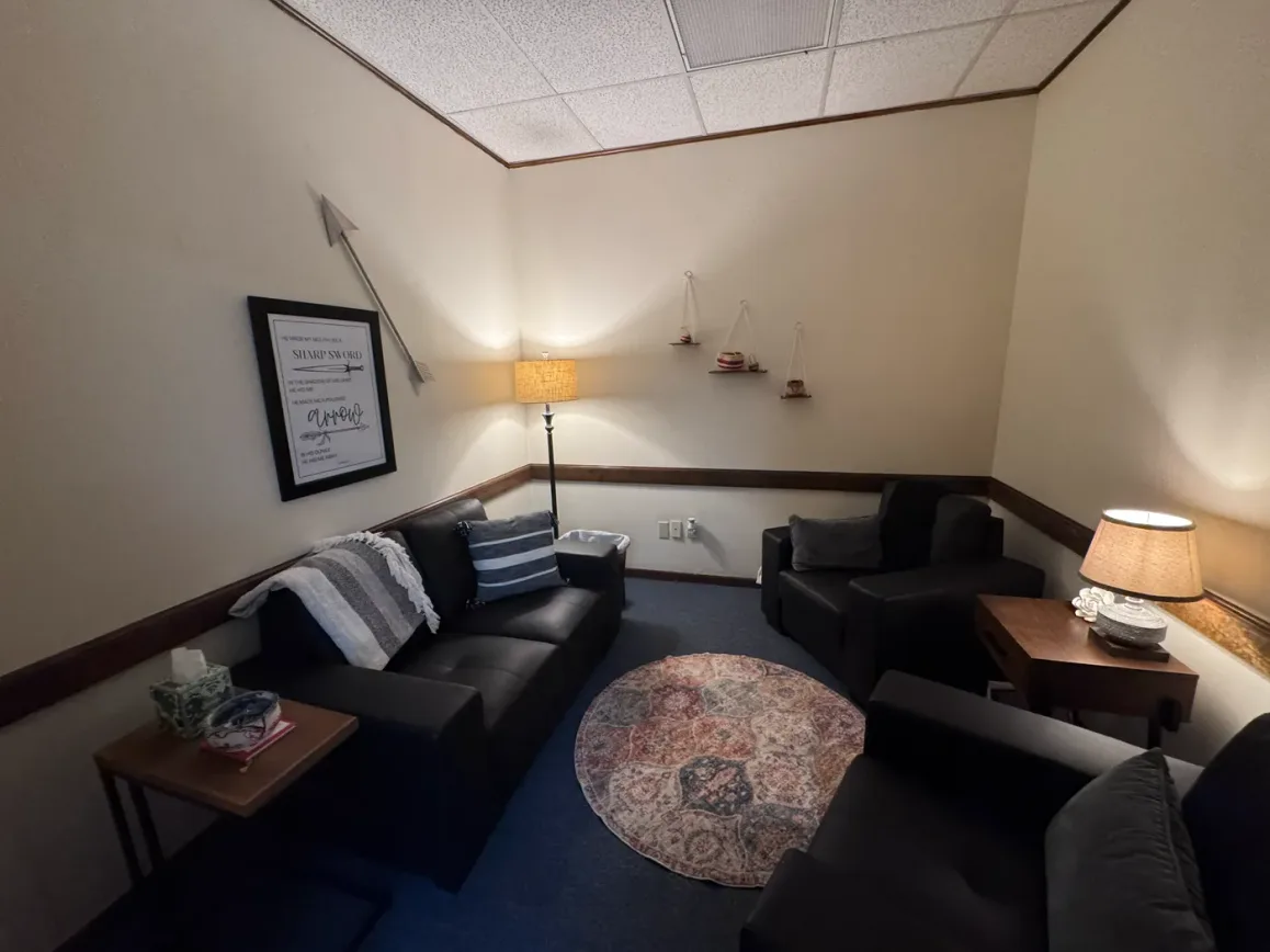 The Healing Office at the Seek the City prayer room — a private space with two leather sofas, warm lamps and a round patterned rug.